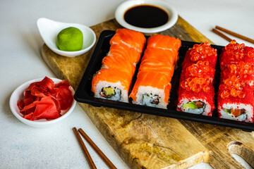 Sushi Set sashimi and sushi rolls served on stone slate