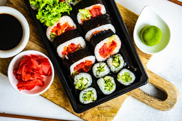 Sushi Set sashimi and sushi rolls served on stone slate