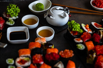 Sushi Set sashimi and sushi rolls served on stone slate