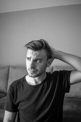 Black and White, Young european man isolated on a green background tired and very sleepy keeping hand on head.