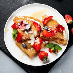 Traditional crepes with filling on gray background