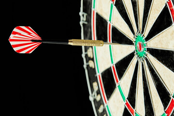 Darts on a black background. 1 dart flies directly to the center of the target. Business center...