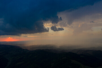 Fototapeta premium Drone view of epic sunset with rainy clouds in Transylvania, Romania.