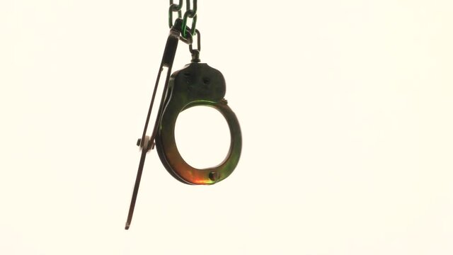Steel handcuffs used in law enforcement and role-playing games. The video was shot in a backlight.