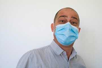 Man wearing a surgical face mask to stop the spread of the Coronavirus Covid 19