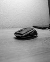 Black and silver wireless mouse on a wooden desk