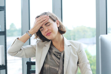 Businesswoman so tried headache and suffering stress working at office computer table.