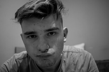 Young male with light brown hair isolated in a room