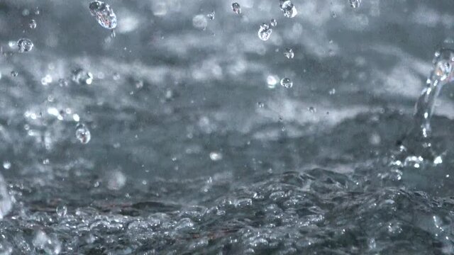 Closeup of water fountain. Abstract aqua background. Rain. Water droplets splashing. 4K