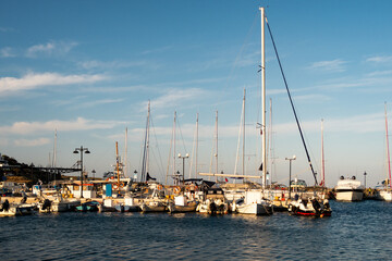 LOUTRA, Kythnos, Greece.  Row of sailing and fishing boats moored at the pier in Loutra Marina Kythnos, Cyclades Islands, during golden hour. 