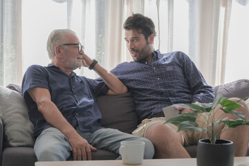 Old father and son happy talking in cozy living room house. Family spending time or sharing story...
