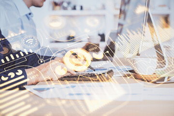 Technology theme hologram with man working on computer on background. High tech concept. Multi exposure.