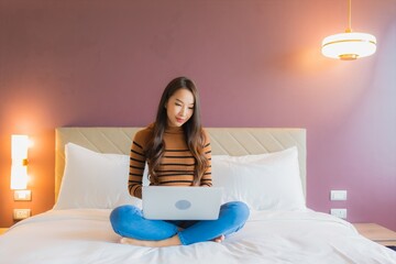 Portrait beautiful young asian woman use laptop computer on bed