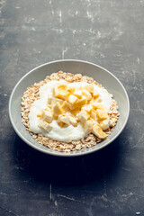 Healthy and tasty breakfast with muesli, yogurt, bananas and honey. Selective focus.
