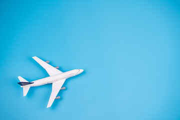 Naklejka na ściany i meble Concept of travel vacation. Top view white toy airplane isolated on blue background with copy space. Minimal think.