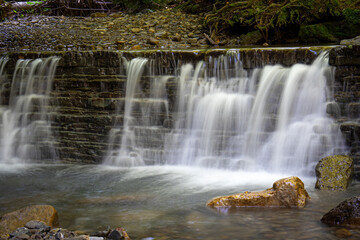 Beautiful waterfall in the rocky mountains. Frozen water. The Carpathian mountains.