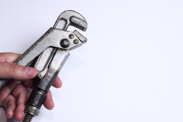 Adjustable wrench in hand on a white background in the photo on the left