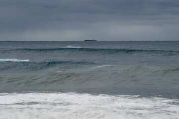 Bib waves rolling into the beach, massive surf day