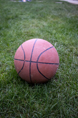 Basketball laying on grass in a park AM
