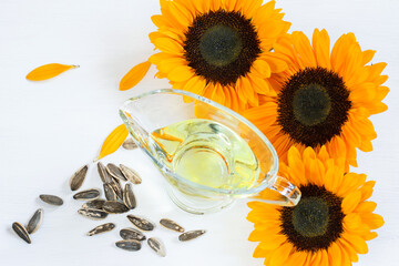 Sunflower heads, sunflower oil and seeds on the white background, top view. Thanksgiving, harvest...