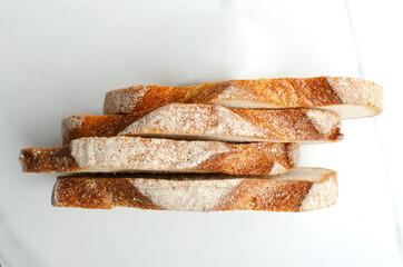 Top view of pieces of rye bread on the white kitchen table.Crusty bread