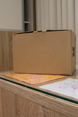 Cardboard box laying on a wooden glass table AM