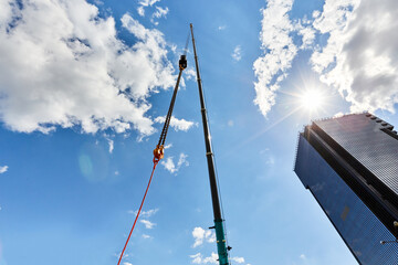 truck crane with outstretched boom on blue sky background