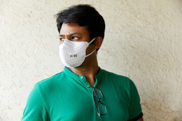 Well Built South Asian Indian Man in N95 Respirator Facing rightward 45 degrees