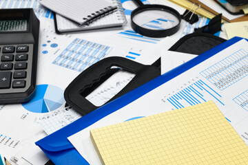 business office desk closeup - financial reports, analysis and accounting, set of documents, tables and graphs, various items for bookkeeping, calculator