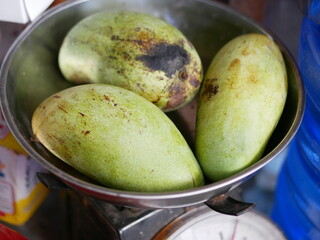 Ripe mangoes fruit on weight scale. Suitable for groceries and fresh market concept.