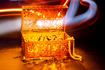Magic, magic box with a Genie. Wooden box with precious jewelry, gold, chain, rings. Wood is carved...