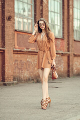 Young woman with earphones walking on the sidewalk