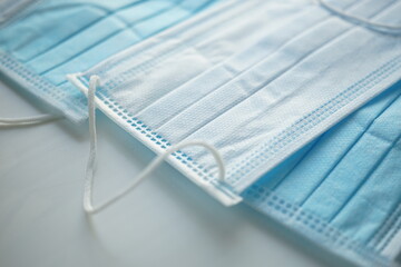 Blue white medical face masks on the table. Side view, closeup.