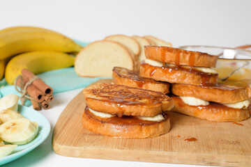 step by step recipe portioned French toast with banana and caramel homemade with cinnamon, dessert on a blue plate on a light background. ingredients for making homemade toast