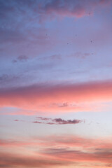 Beautiful evening blue sky at sunset with flaming bright light clouds. A warm summer evening at sunset.