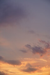 Beautiful evening blue sky at sunset with flaming bright light clouds. A warm summer evening at sunset.