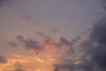 Beautiful evening blue sky at sunset with flaming bright light clouds. A warm summer evening at sunset.