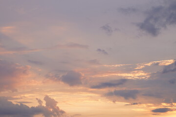 Fototapeta premium Beautiful evening blue sky at sunset with flaming bright light clouds. A warm summer evening at sunset.