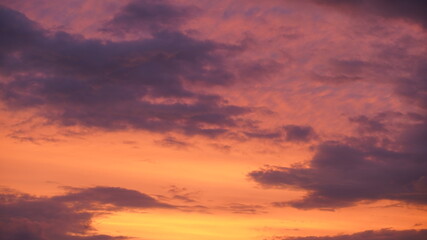 Beautiful evening blue sky at sunset with flaming bright light clouds. A warm summer evening at sunset.