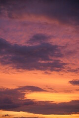Beautiful evening blue sky at sunset with flaming bright light clouds. A warm summer evening at sunset.