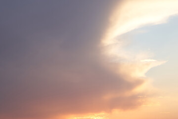 Beautiful evening blue sky at sunset with flaming bright light clouds. A warm summer evening at sunset.