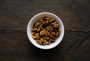 Walnut in a small plate on a vintage wooden table. Walnuts is a healthy vegetarian protein nutritious food. Natural nuts snacks.