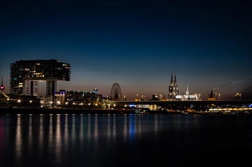 Fototapeta premium Nachtaufnahme Kranhäuser am Rheinufer in Köln mit Blick auf den Kölner Dom