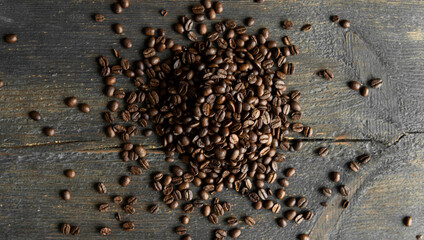 Roasted arabica coffee beans scattered on a wooden table. Fresh coffee beans.