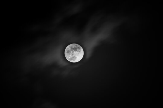 A monochrome image of the moon with light clouds. Clicked by Kiran Kedilaya