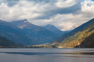 Panorama view of Poschiavo lake and Swiss Alps on the way of sightseeing train of Bernina Express on cloudy autumn day, Canton of Grisons, Switzerland