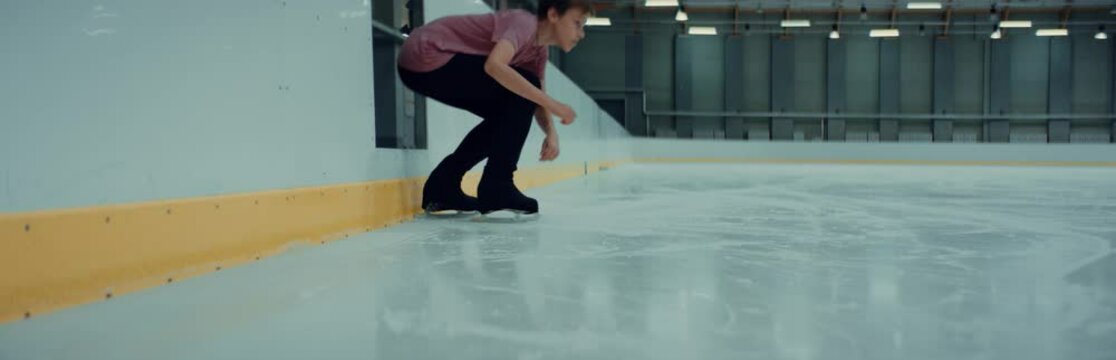 Professional Teenager Boy Figure Skater Tying Laces On Skates Before Training On Indoor Ice Arena. Shot On RED Cinema Camera With 2x Anamorphic Lens, 75 FPS Slow Motion