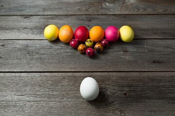 Hand painted easter eggs arranged like for billiards on wooden background.