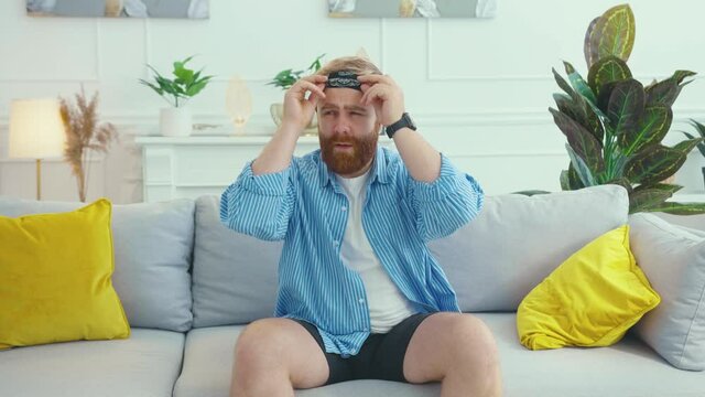 Caucasian young father taking off blindfold searching for his adorable tricky son kid in apartment living room playing hide-and-seek game together.