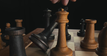 Close up of male hand moving white queen defeating black king. Checkmate